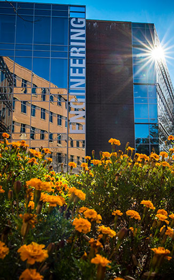 The Nguyen engineering building with yellow flowers in front of it. 
